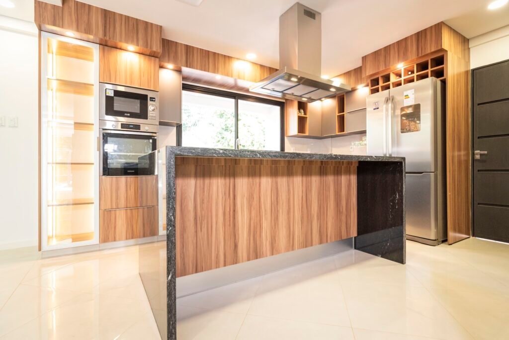 Cocina César: isla y mobiliario en madera con superficies oscuras