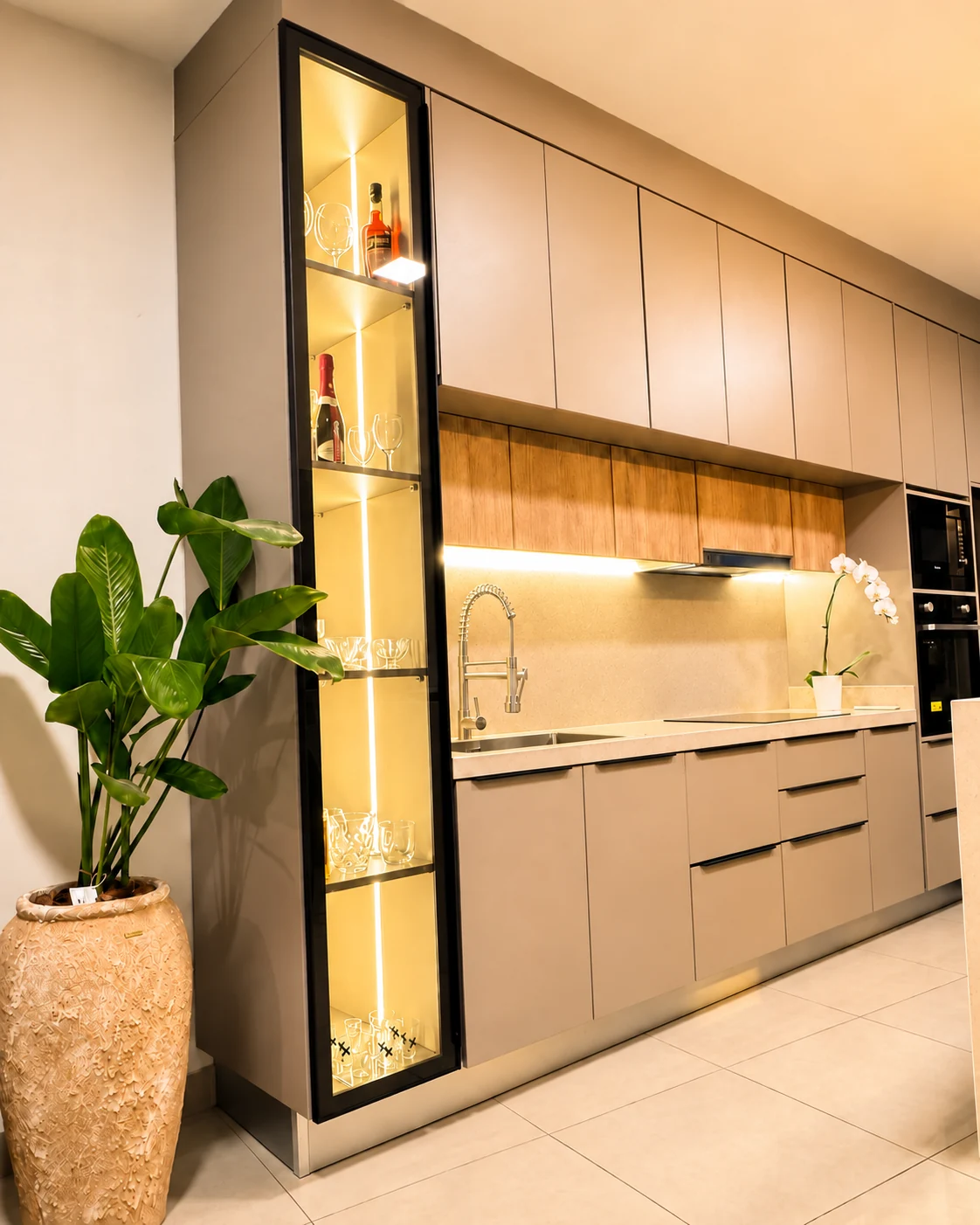 Cocina Amoblarte con vitrina iluminada, muebles en tonos arena y madera
